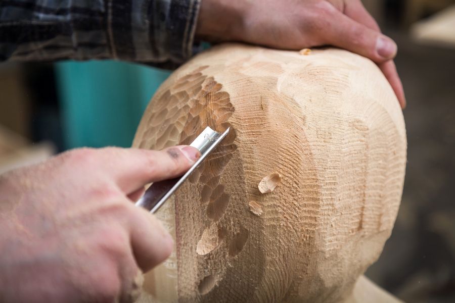 un hombre tallando madera para confeccionar mueble a medida