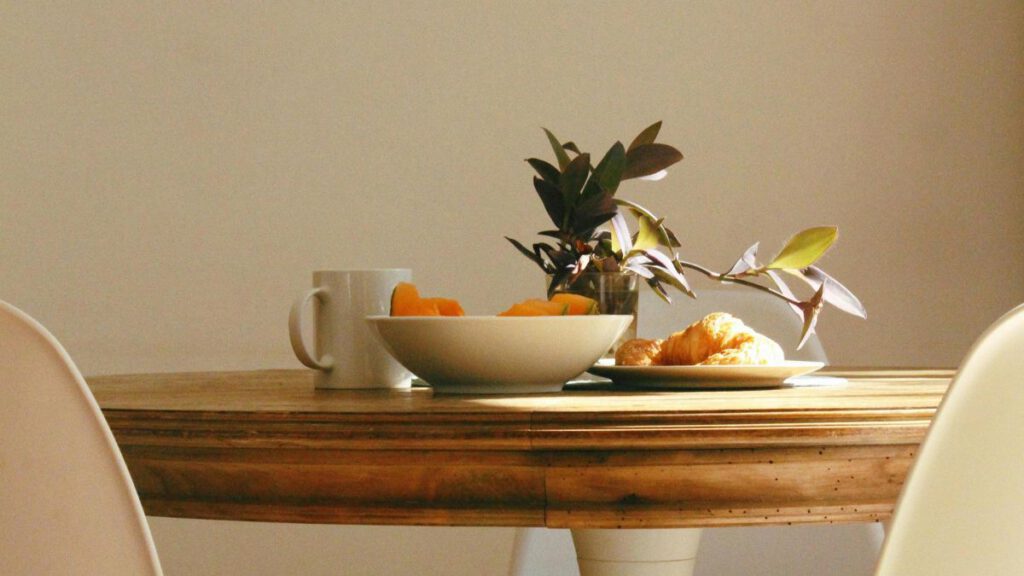 mesa de madera redonda con platos y taza encima